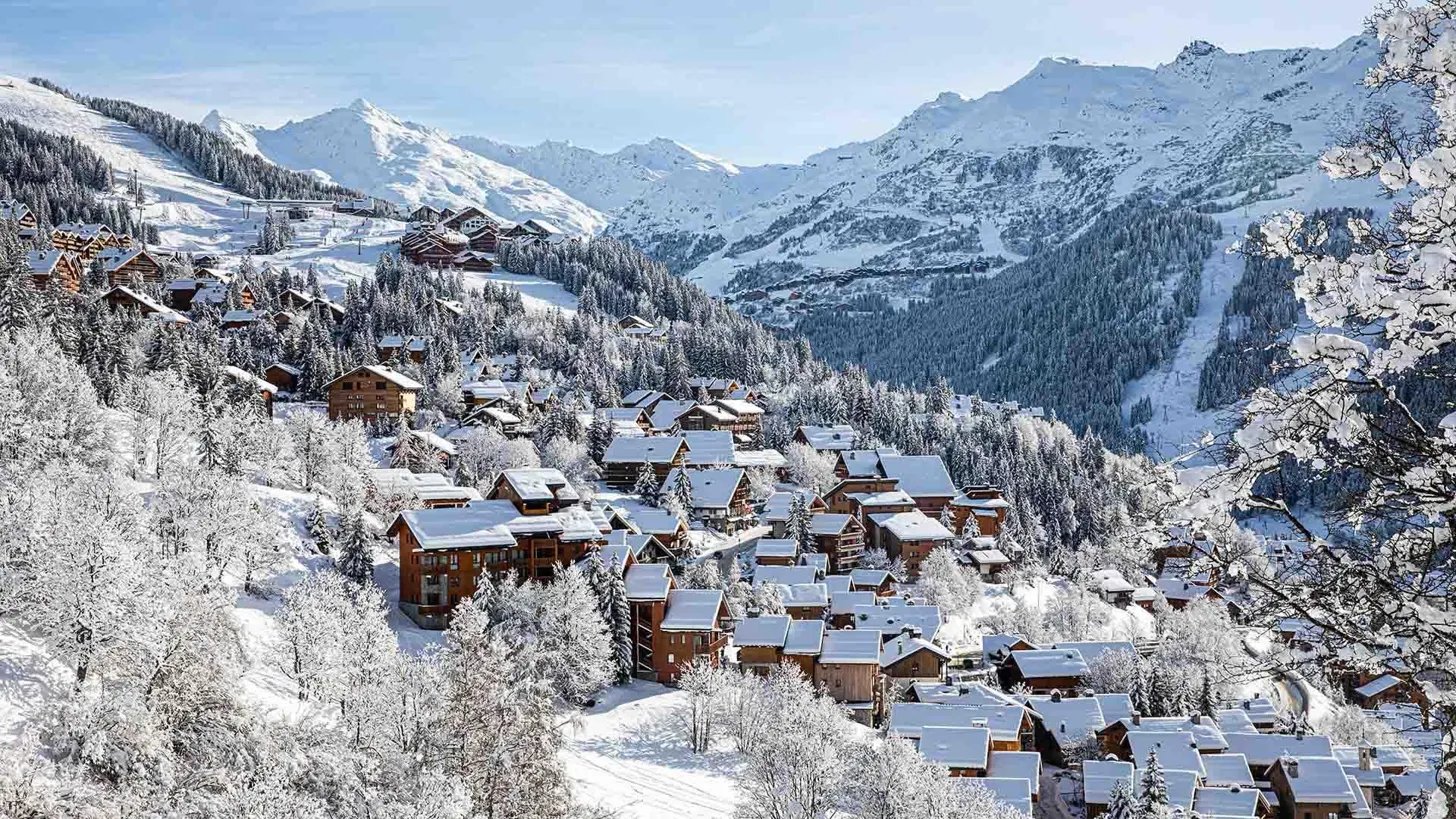 A snow-covered alpine chalet village at dusk