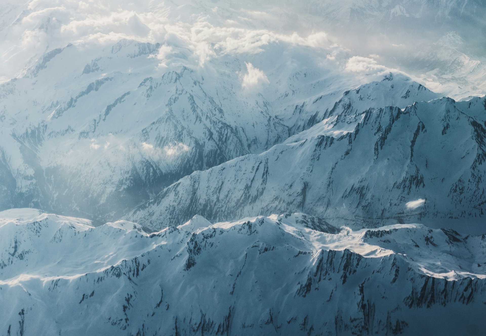 A clean aerial view of snow-covered alpine peaks and ridgelines